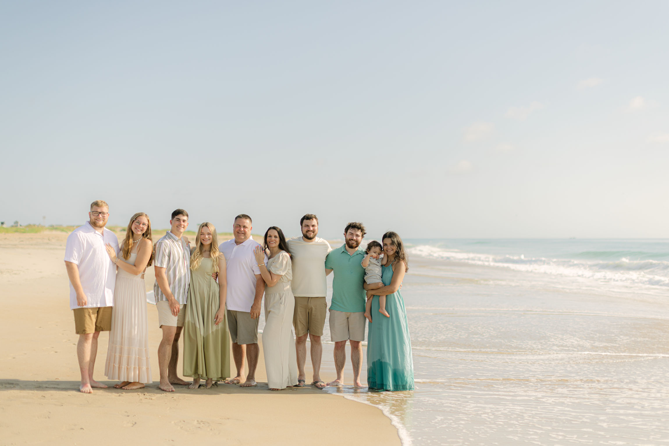 Family photo wearing neutral coordinated outfits on the beach
