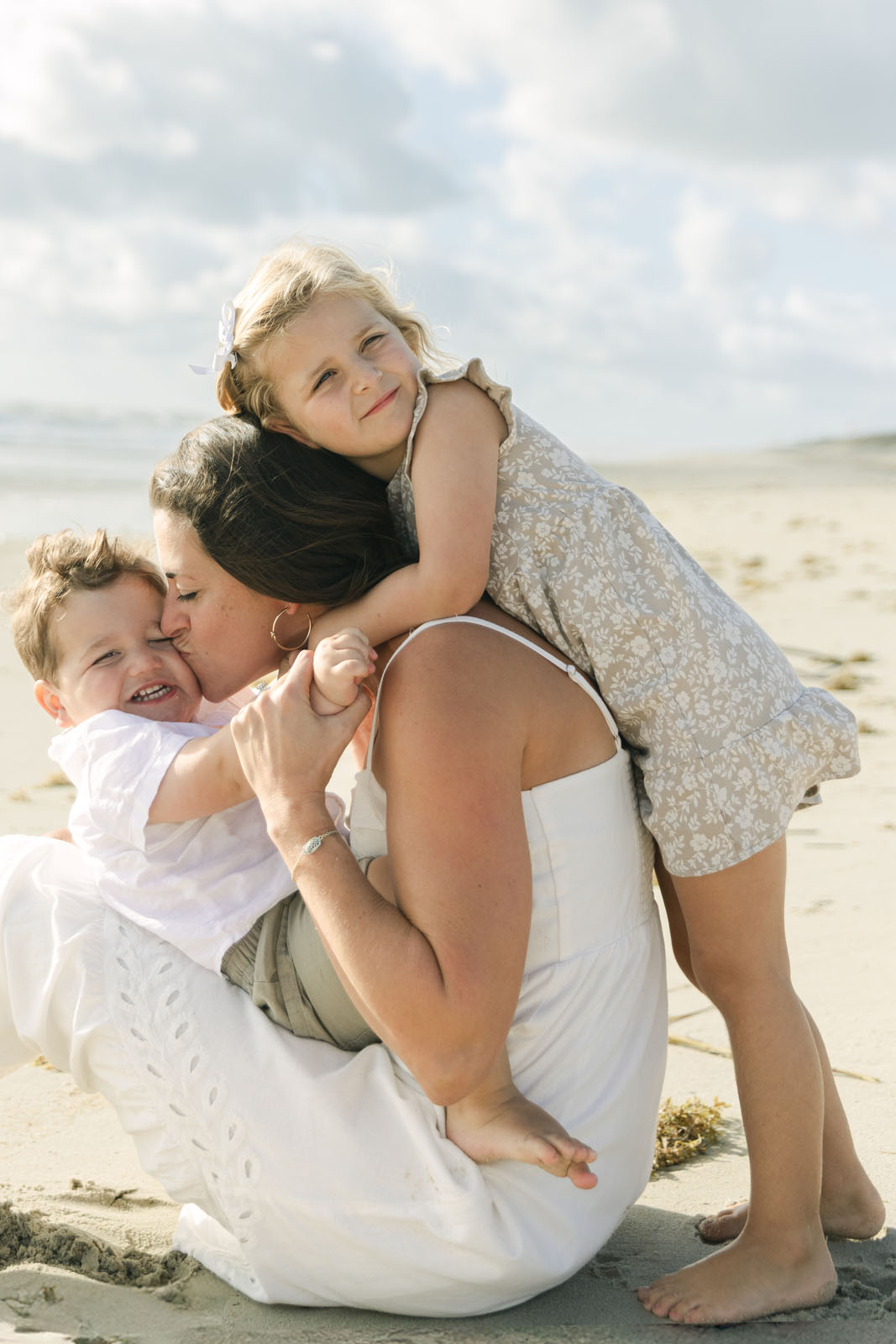 Mother with her toddlers on the beach