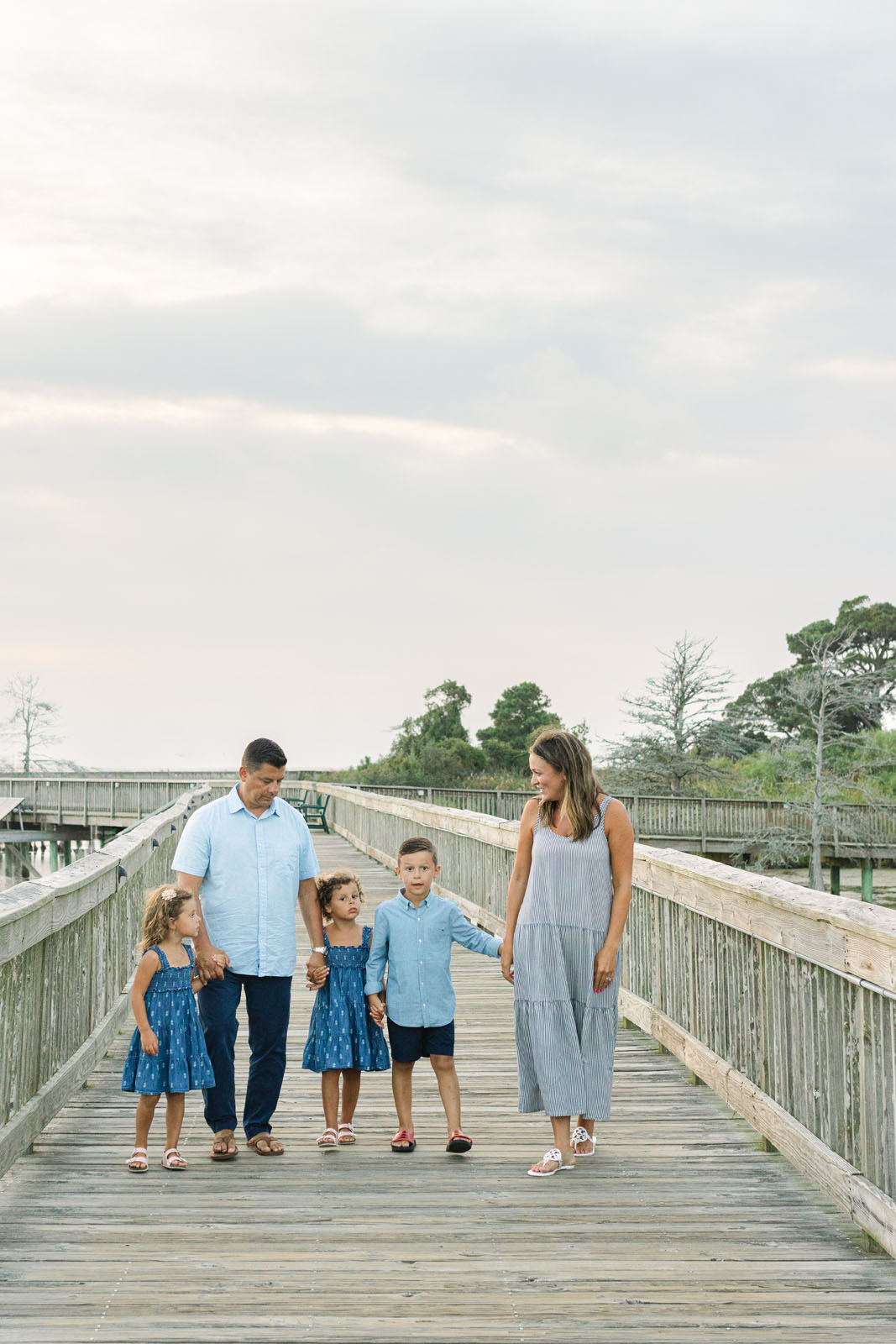Family walking along the Duck Boardwalk during a sunset photo session in Duck North Carolina