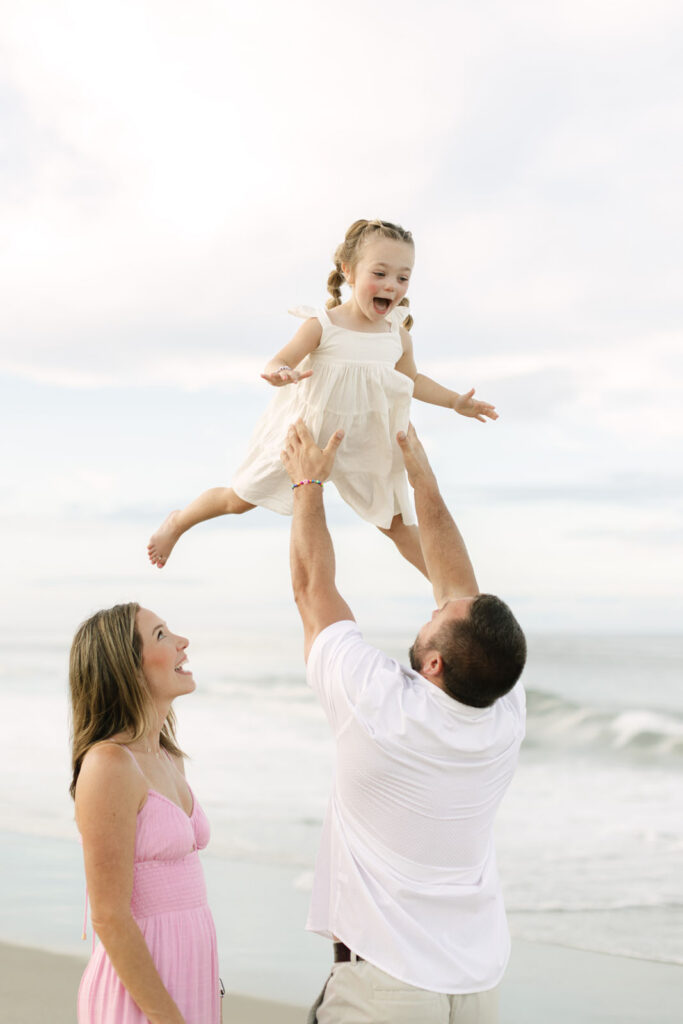 parents lifting their child on the beach in Corolla nc 