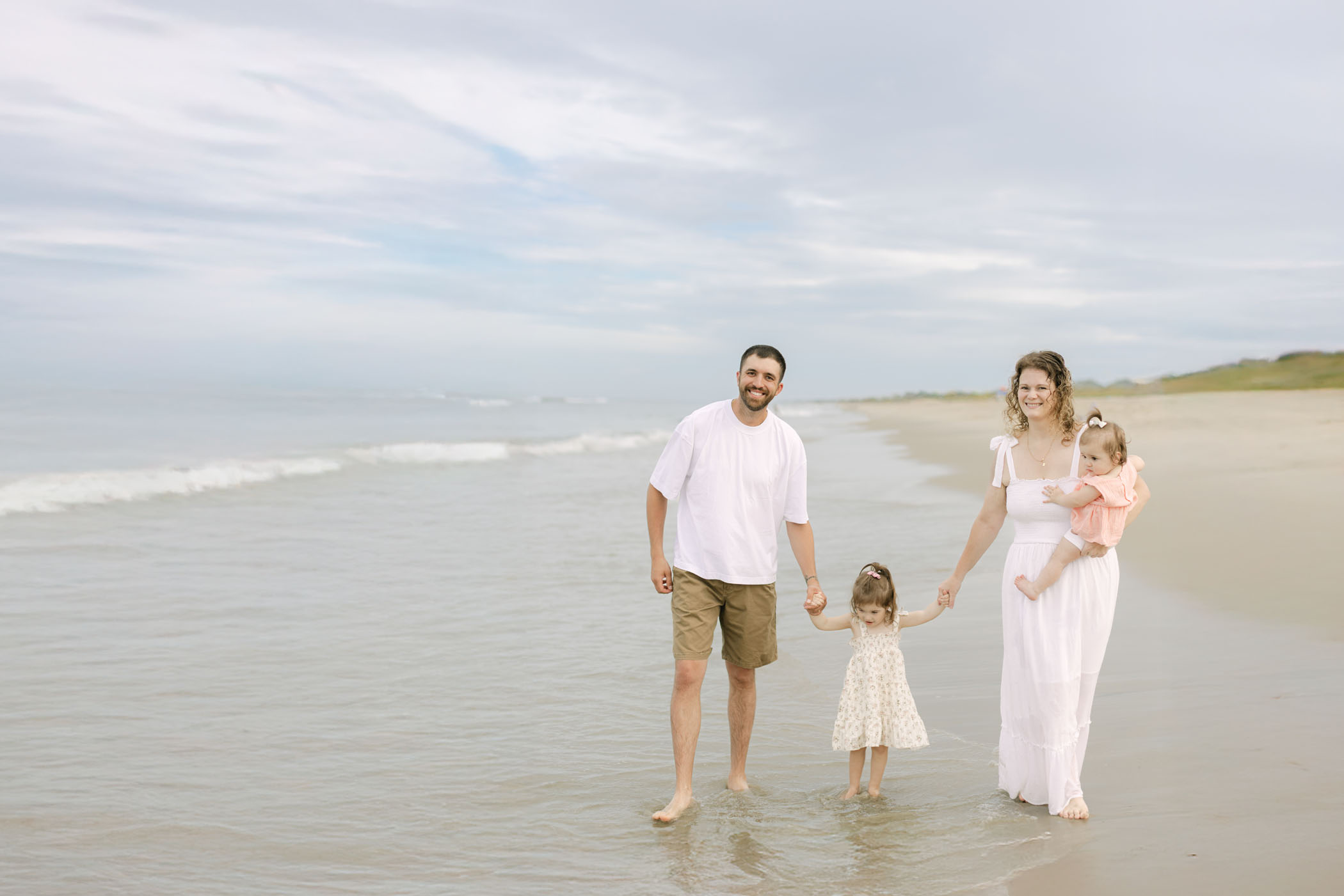 Outer Banks family walking along the shoreline during a relaxed sunset beach photo session