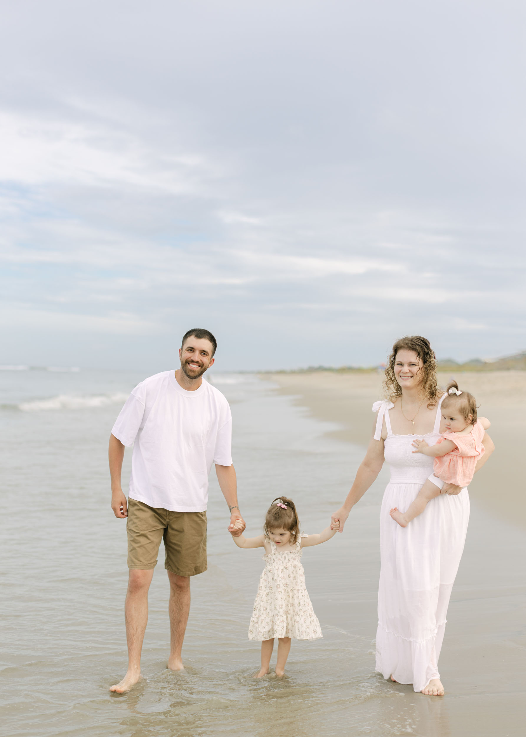 Outer Banks family walking along the shoreline during a relaxed sunset beach photo session