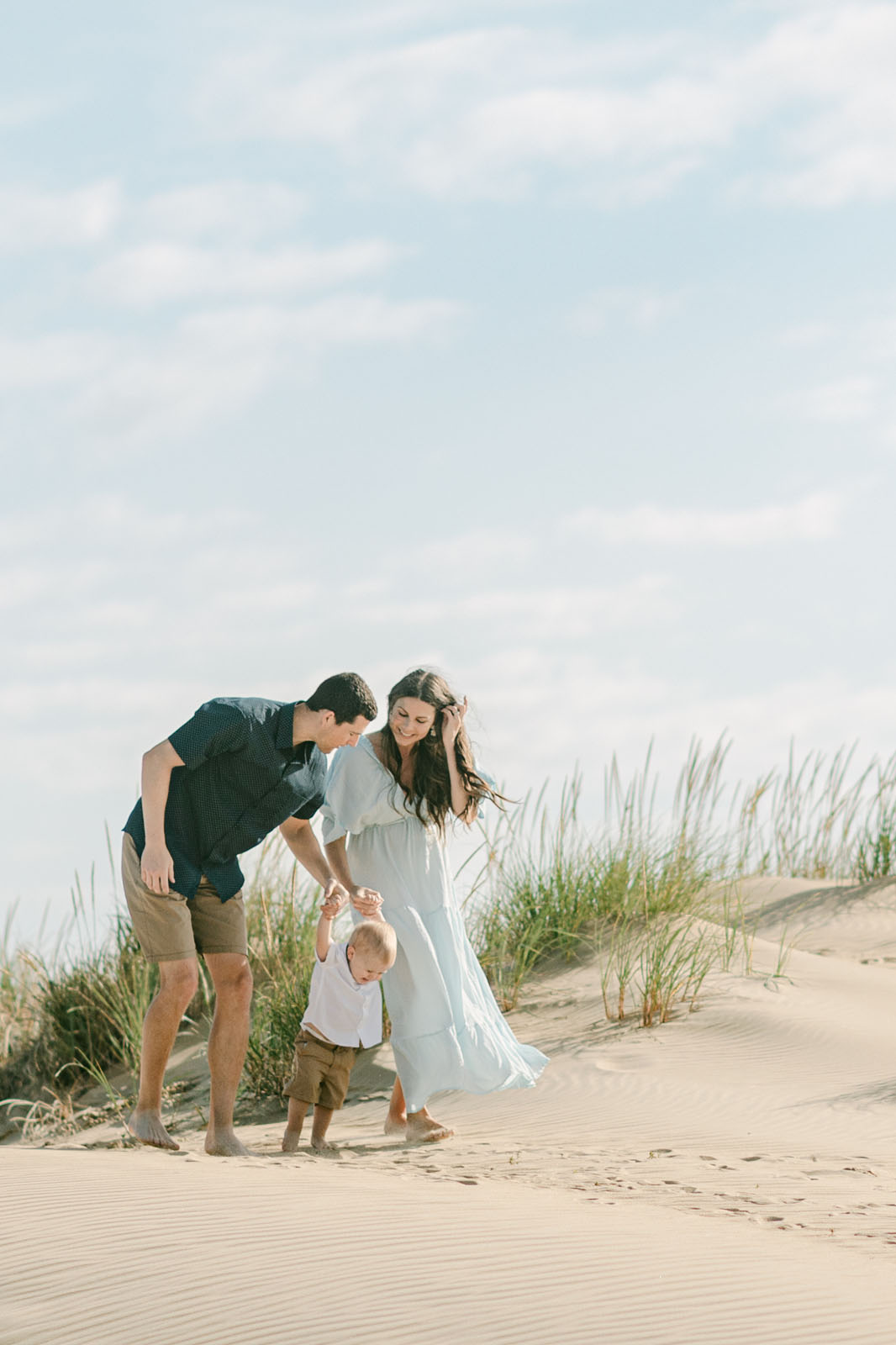 Family walking through the sand dunes at Jockey’s Ridge State Park during an Outer Banks portrait session