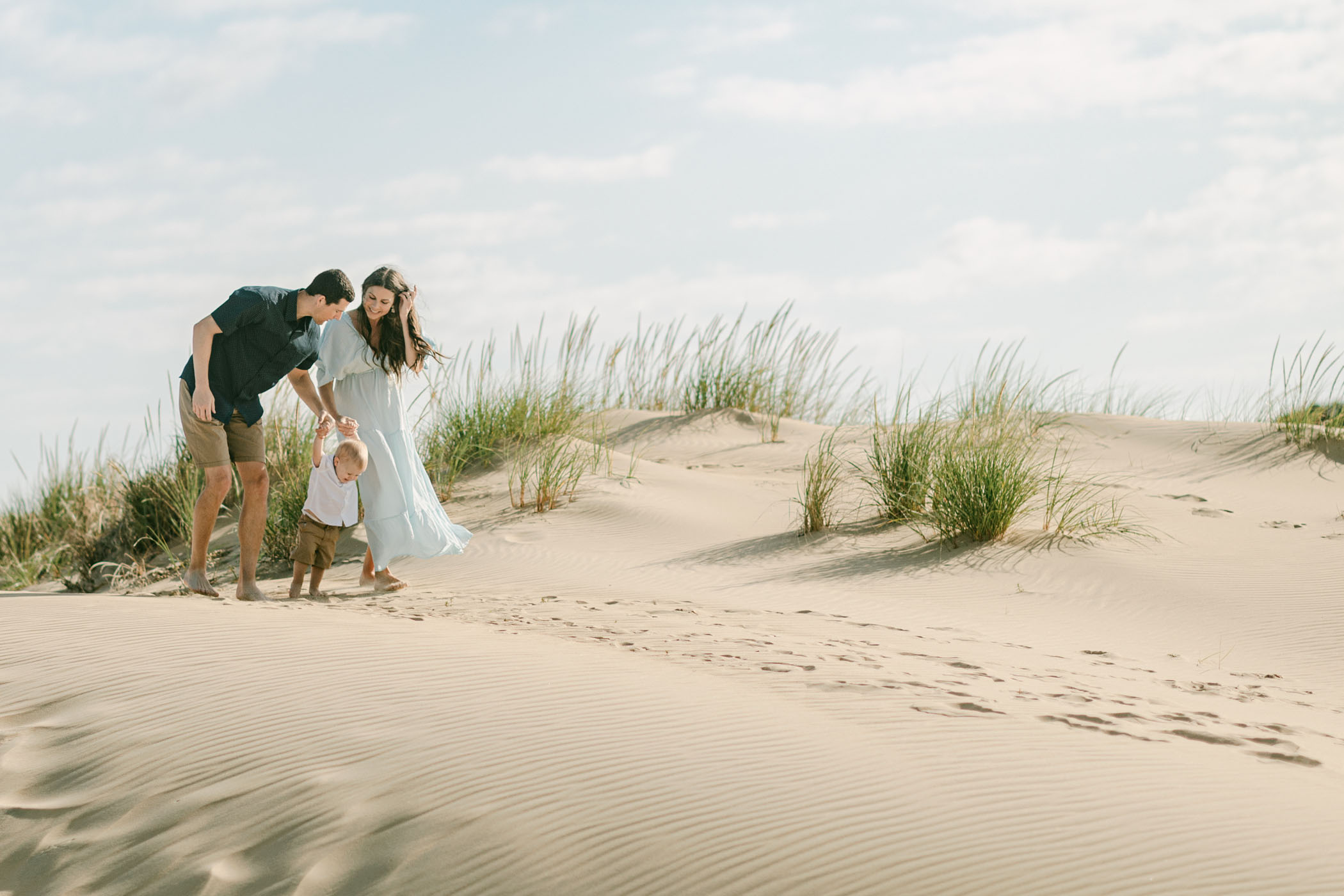 Family walking through the sand dunes at Jockey’s Ridge State Park during an Outer Banks portrait session