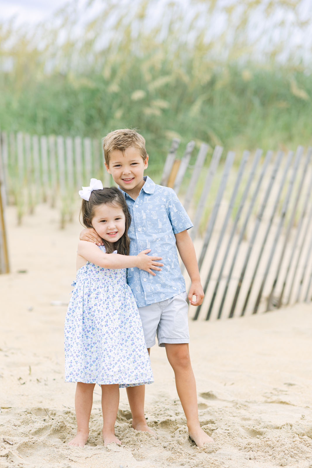 Two siblings standing together on the beach in the Outer Banks
