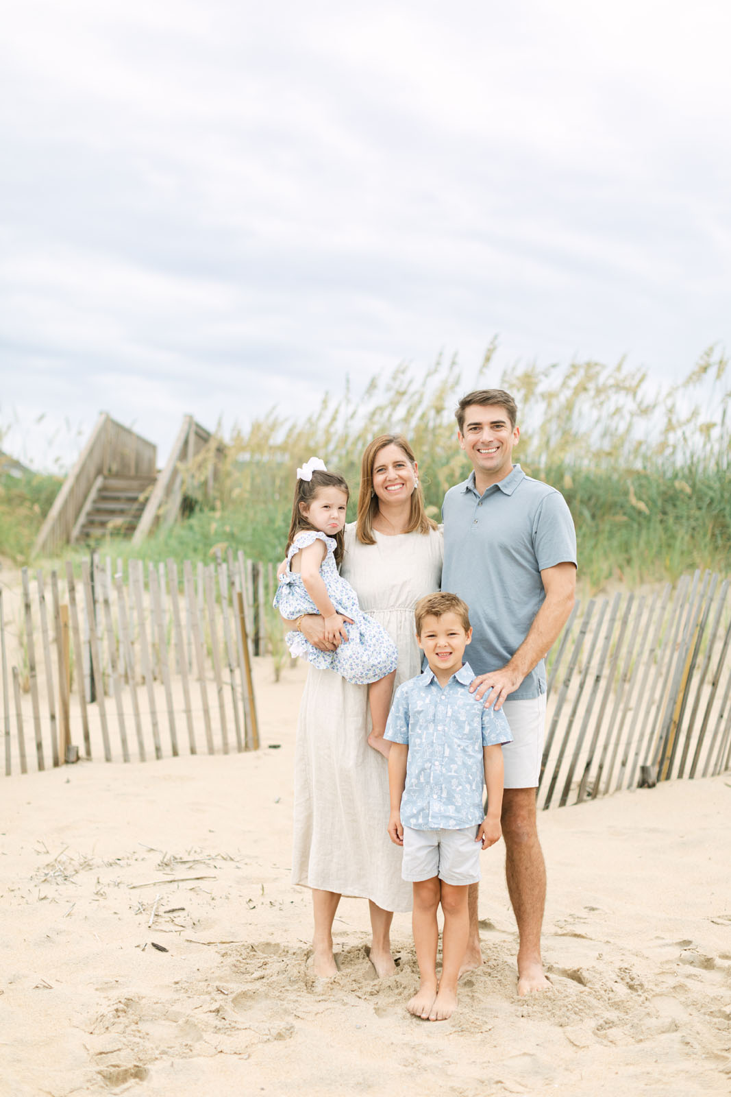 Family of four posing together on the beach in the Outer Banks