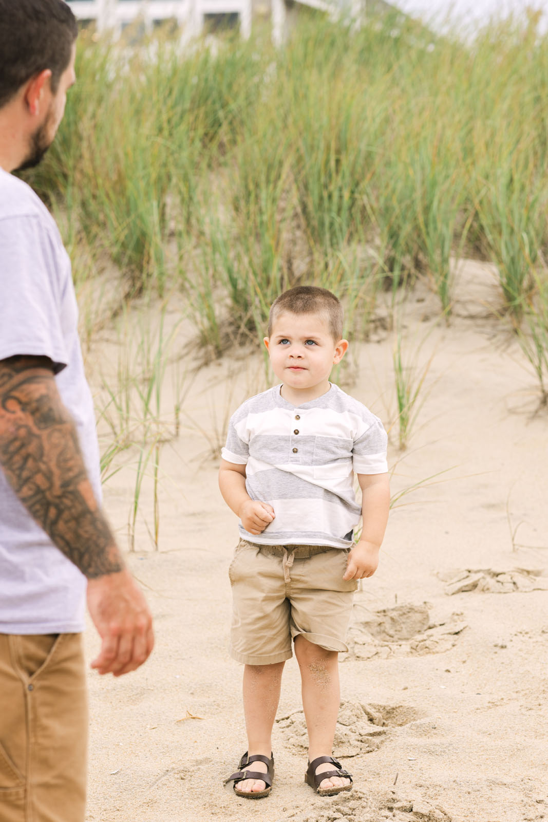 Young boy standing on the beach during a family photo session
