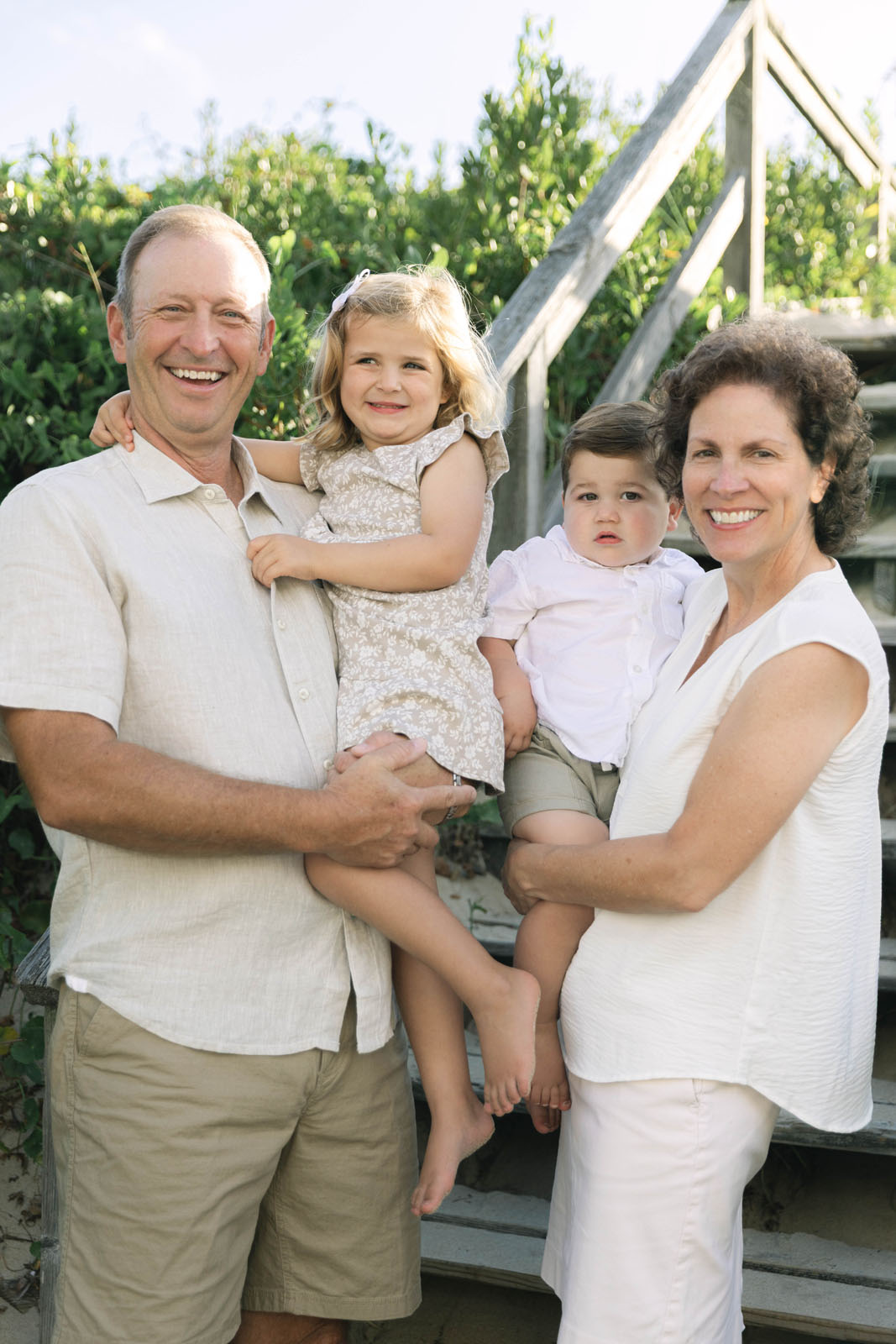 Grandparents and grandchildren during a morning photo session by the beach entrance 
