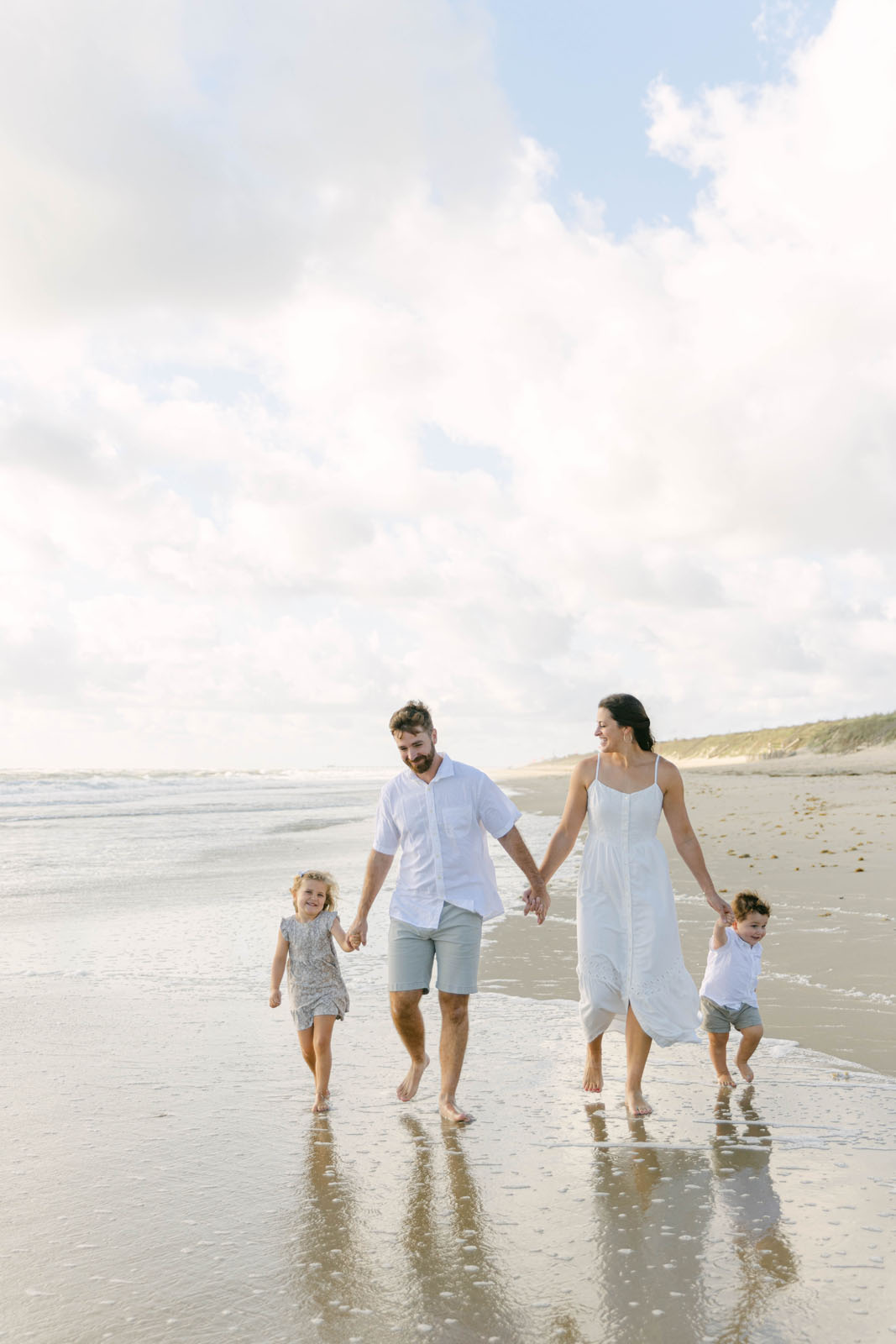 Family walking together on the beach during a Kitty Hawk NC photo session