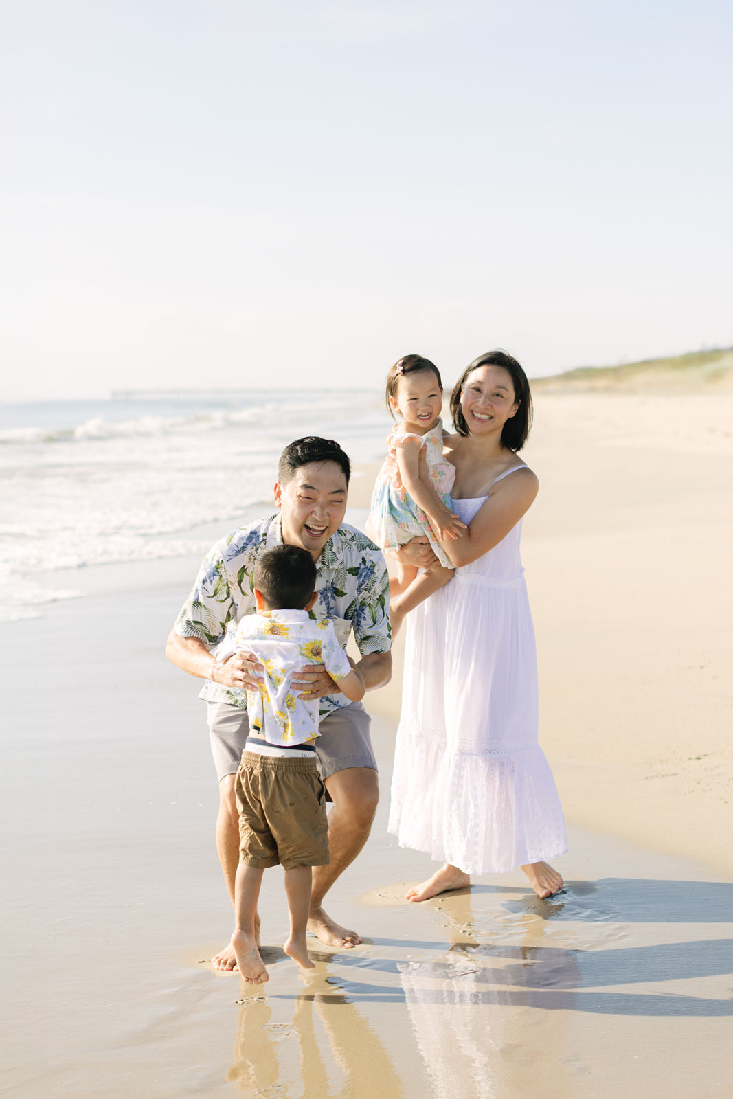 Family with young children enjoying a morning beach photo session on the Outer Banks