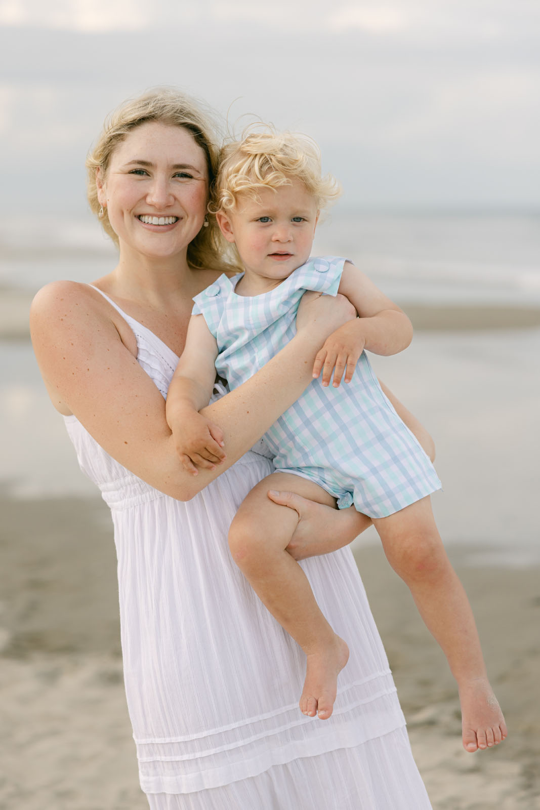 Mother holding her toddler during an evening family photography session on the Outer Banks